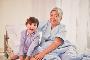Fototapeta premium Patient Concept. Grandma's in the hospital. Waiting for someone to visit. Grandchildren visit grandma at the hospital. Grandma is happy to meet grandchildren.