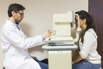 Photo of patient looking at medical apparatus during vision checking in ophthalmological laboratory...