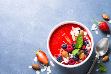 Smoothie bowl from strawberry with fresh berries and nuts. 