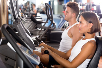 Man and woman workout using cycling cardio machines