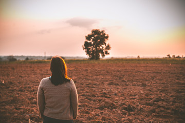 Portrait of lonely woman alone in a field. Vintage filter style.she heartbreak from love,sad girl...