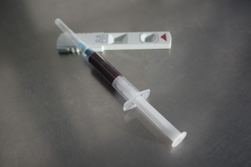 Troponin T test : test for look heart attack of the myocardium for diagnostics in laboratory. syringe with blood and troponin test on the medical table