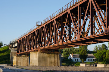 Big steel railway bridge with a concrete base in rural place