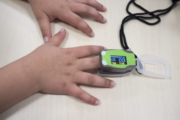 Doctor measuring little girl's measuring oxygen and heart rate
