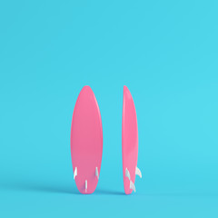 Pink surfboard on bright blue background in pastel colors. Minimalism concept
