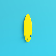 Yellow surfboard on bright blue background in pastel colors