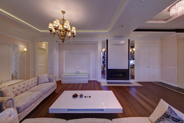 A fireplace in a light drawing room with light upholstered furniture