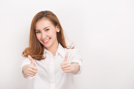 Happy young woman giving thumbs up on white background