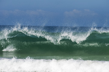 A wave breaks onto the sand