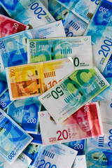 Pile of NIS - New Israeli Shekels banknotes with the new 200, 100, 20, 50 sheqel. Wallpaper of shekels bills -Top View. Politics and money of Israel background.