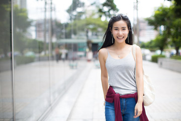 Summer sunny lifestyle fashion portrait of young stylish hipster woman walking on the street, wearing cute trendy outfit