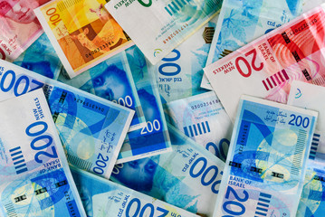 Pile of NIS - New Israeli Shekels banknotes with the new 200, 100, 20, 50 sheqel. Wallpaper of shekels bills -Top View. Politics and money of Israel background.