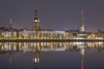 Evening view on the embankment of the Daugava River and the spiers of churches in Riga