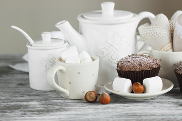 Cups with cacao and marshmallow, cupcakes and different decorations
