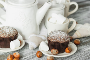 Cups with cacao and marshmallow, cupcakes and different decorations