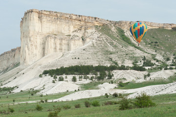 Multicolored balloon near the White rock in spring