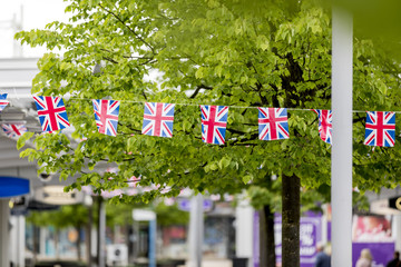 Union Jack bunting flapping in the breeze celebrating British event outside a shopping centre in England, United Kingdom