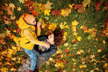 Happy Family Lying on Grass Outdoors. Parental Care and Love Concept