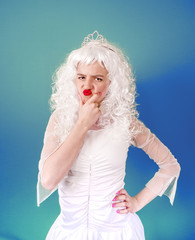 Photo of upset woman with red lips wearing white curly wig looking at camera with anger isolated over blue background