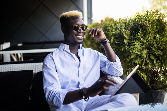 Handsome business man works from his office at an outdoor coffee shop with his laptop and wireless internet connection