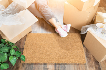 Woman Wearing Sweats Relaxing Near Home Sweet Home Welcome Mat, Moving Boxes and Plant