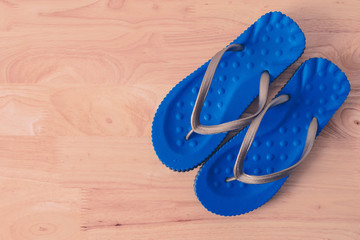 Blue sandal shoes on wooden table, top view