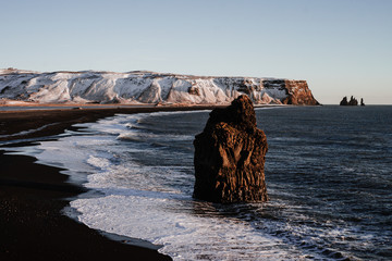 A rock in the ocean at Reinsfjara Beach, Iceland