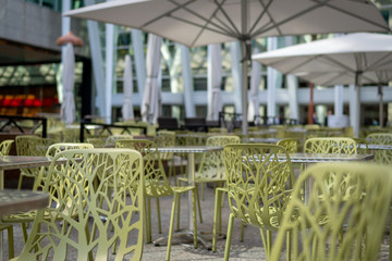 Outdoor patio with designed chairs, metal tables, and white umbrellas