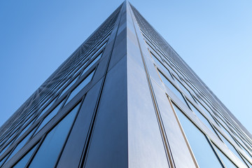 Fototapeta na wymiar Up view of office building with windows blue skies