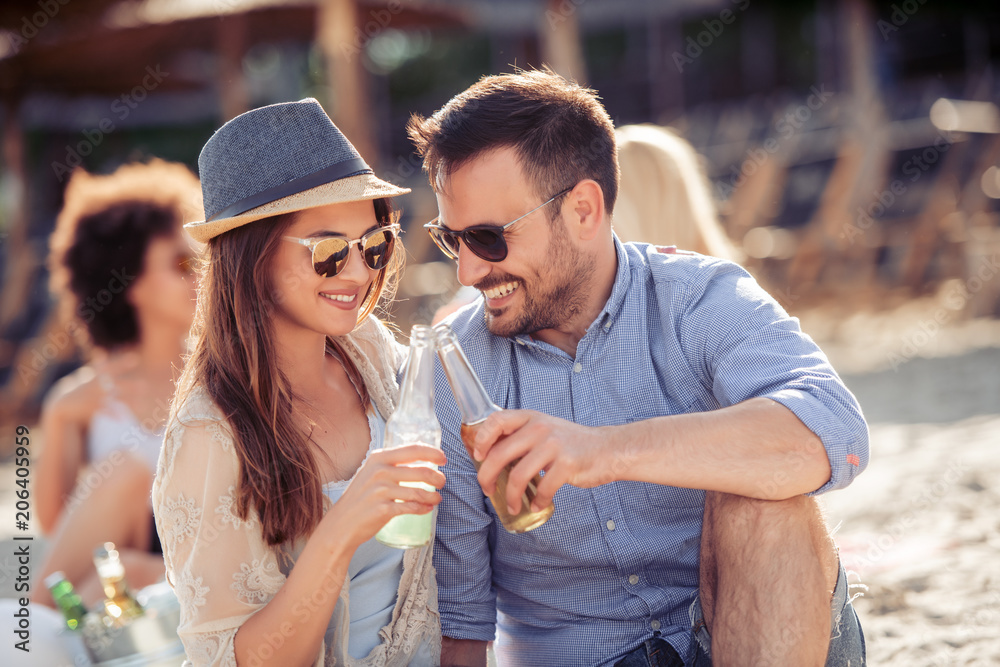 Poster Portrait of happy couple picnic together at the beach and having fun