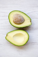 Avocado on white wooden background, top view. Flat lay, above.
