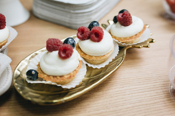 delicious eclairs with fresh raspberries, blueberries and cream.