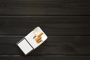 a pack of cigarettes, on a dark wood background