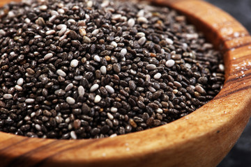Healthy Chia seeds in a wooden spoon on the table close-up