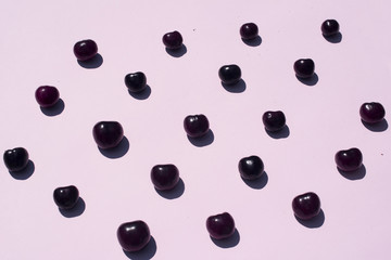 Minimal natural pattern of some cherries over pink background