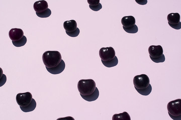 Minimal natural pattern of some cherries over pink background