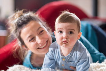 Mum plays with her cheerful baby at home
