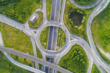 Aerial view of highway road junction. Highways, railway and green fields on the outskirts of the city. Transport concept.outskirts of the city. Transport concept.
