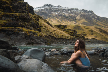 Young woman sitting in mountain river