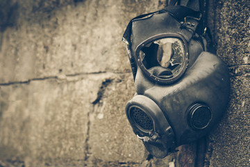 Broken gas mask hung on the wall / Toxic chemical weapon concept