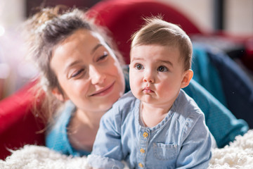 Obraz premium Mom plays with her cheerful baby at home