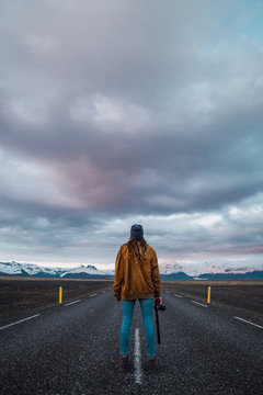 Woman on road looking at mountains