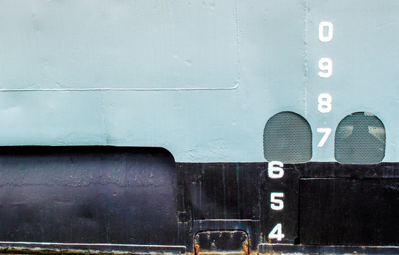 close up of white draft marks on the gray and black hull of the historic USS Torsk submarine in Baltimore's Inner Harbor with copy space