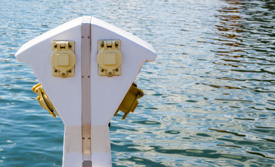 a white and yellow nautical power pedestal on the waterfront at Baltimore's Inner Harbor with copy space