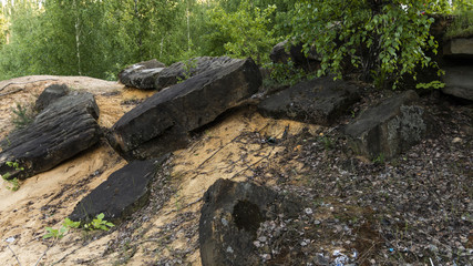 Fototapeta na wymiar Stones on the yellow sand in a granite quarry