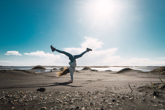Happy tourist doing handstand in nature