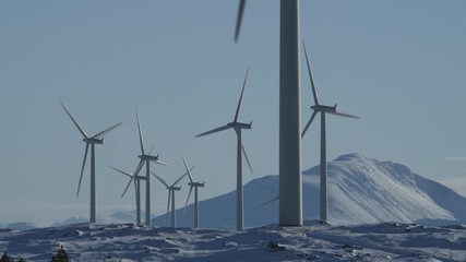 Windmills in winter landscape. Various windmills beautifully framed against snow covered moors, rolling hills and peaks in a frosty winter landscape on a bright sunny winter day in Norway