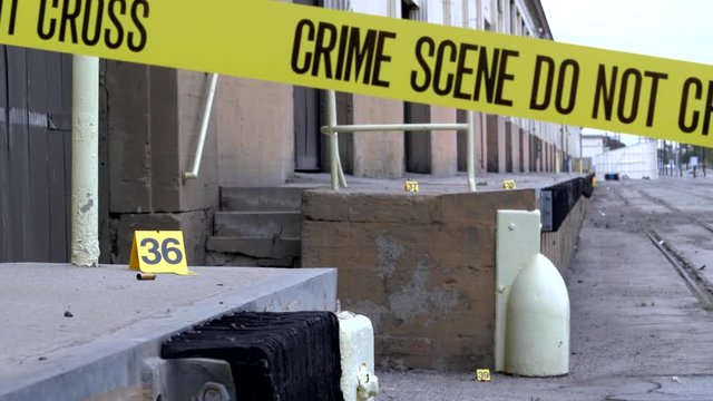 INDUSTRIAL CRIME WITH SHELL CASINGS MARKED AS EVIDENCE.  4K slider shot.