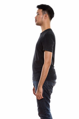 Profile view of young Asian man standing