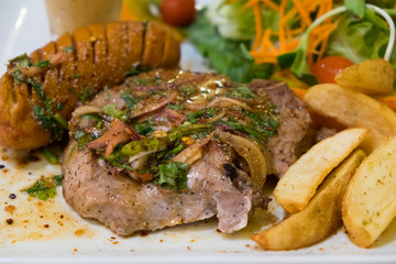 Spicy pork chop with sausage and potato.